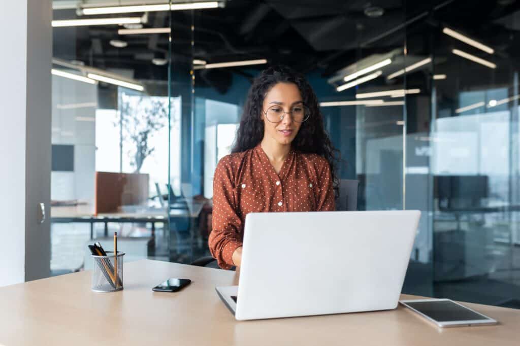 Cheerful and successful indian woman programmer at work inside modern office, tech support worker